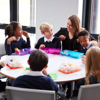 teacher-kneeling-to-talk-to-a-group-of-primary-sch-2026-01-05-06-27-34-utc (1) (1)